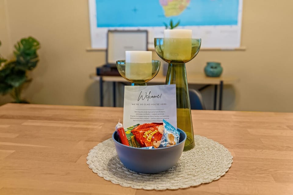 Dining Table Decor and Welcome Amenities: Tasteful table setting with fresh fruit and stylish decor pieces – Cairo St Bungalow Springfield, MO.