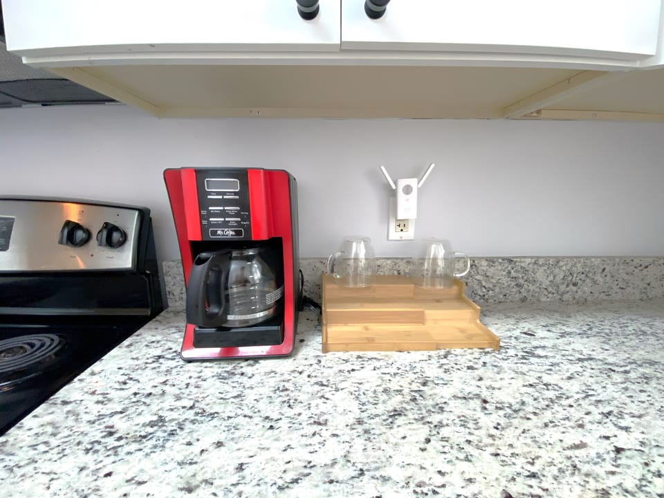 Modern and sunny kitchen with granite countertops, stainless steel appliances.