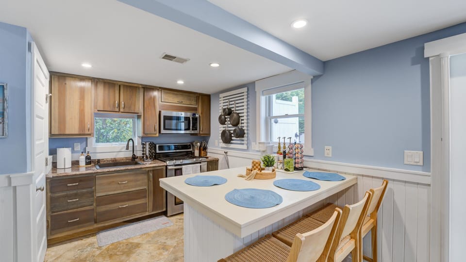 Prepare delicious meals in the spacious kitchen featuring modern appliances, ample counter space, and a convenient dining table for casual dining.