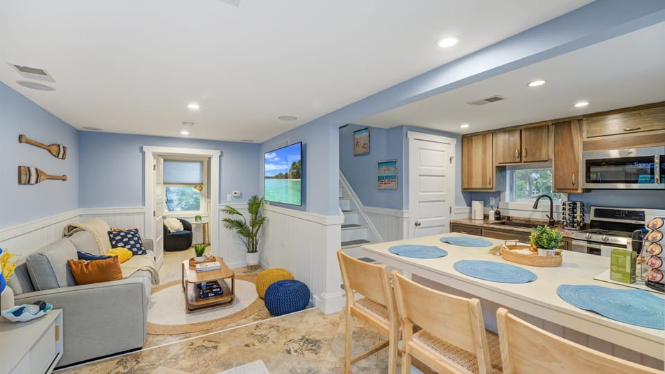 Enjoy the open-plan living area with a cozy seating arrangement, stylish dining space, and a fully-equipped kitchen, perfect for family gatherings and entertaining.