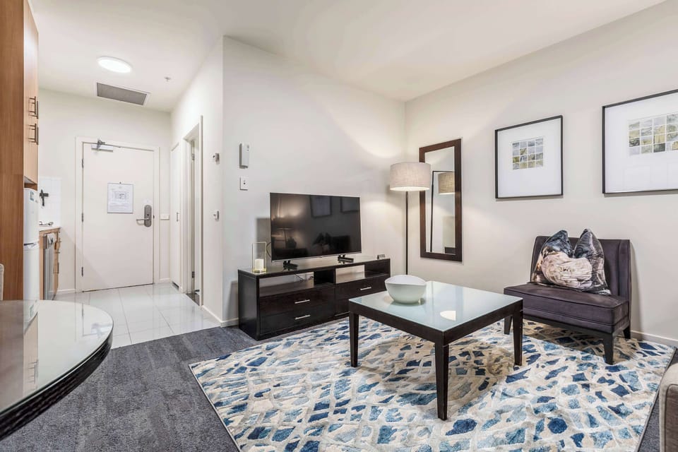 LIVING ROOM: Unwind in a spacious, open layout with a comfortable sofa and smart TV for your entertainment