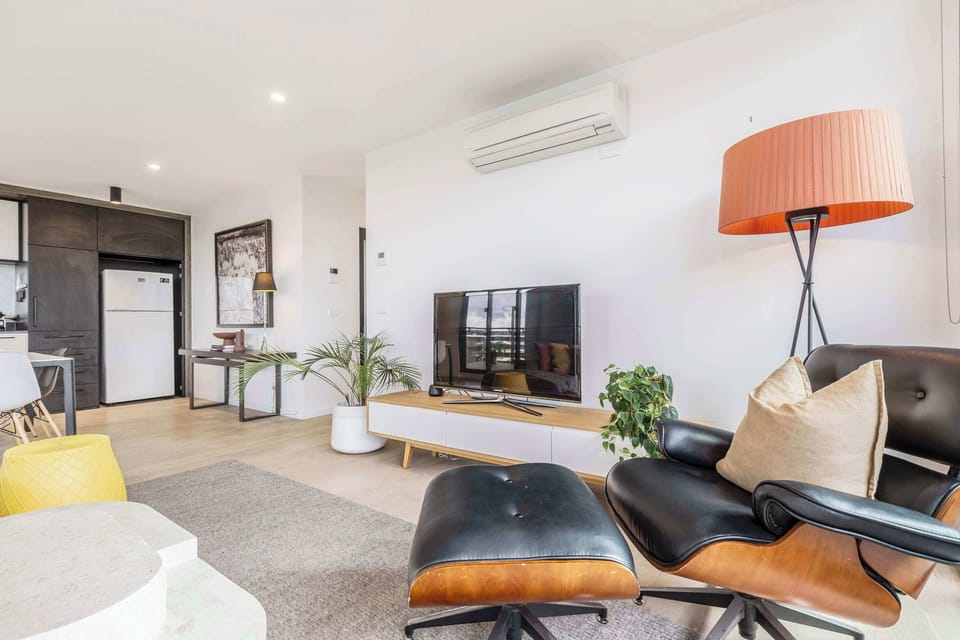 LIVING ROOM: Bathed in natural light, this expansive living space blends effortless comfort with refined style. Gather for conversation, unwind with streaming entertainment, or simply enjoy the calm, airy ambiance