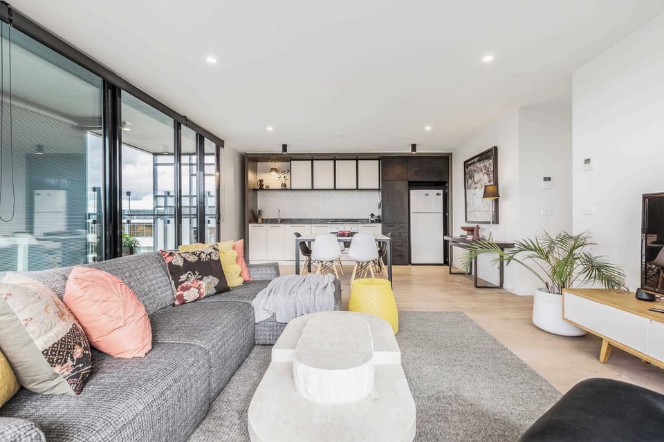 LIVING ROOM: Bathed in natural light, this expansive living space blends effortless comfort with refined style. Gather for conversation, unwind with streaming entertainment, or simply enjoy the calm, airy ambiance