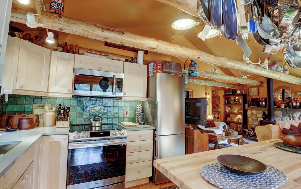 Kitchen with electric stove, microwave refrigerator and island with dishwasher