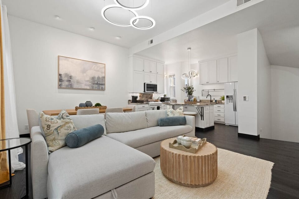 Open living area w/ comfy seating, soft tones & natural light flowing through the space.