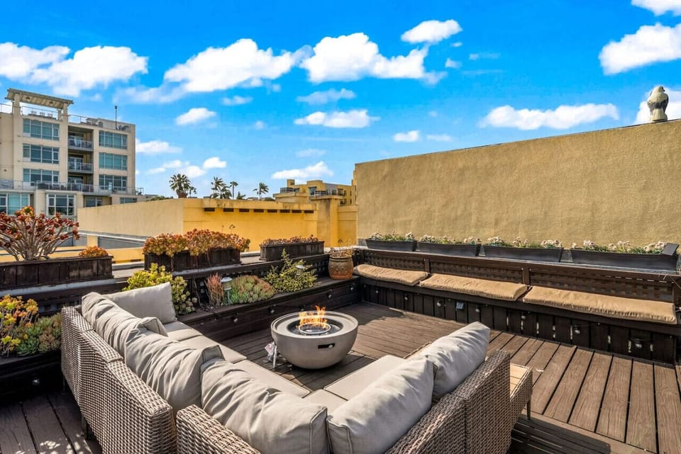 Spacious rooftop lounge w/ cozy seating & open sky views, ideal for unwinding or gathering together.