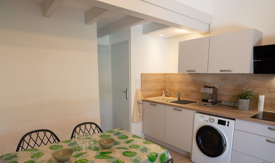Air-conditioned living room with fitted kitchen, dining table and TV.