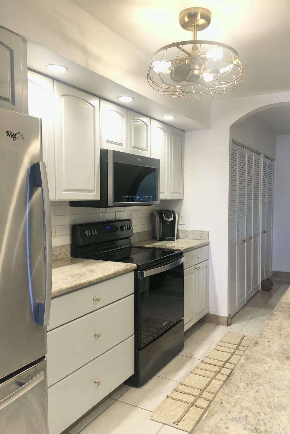 freshly painted cabinets, designer brass hardware and faucet