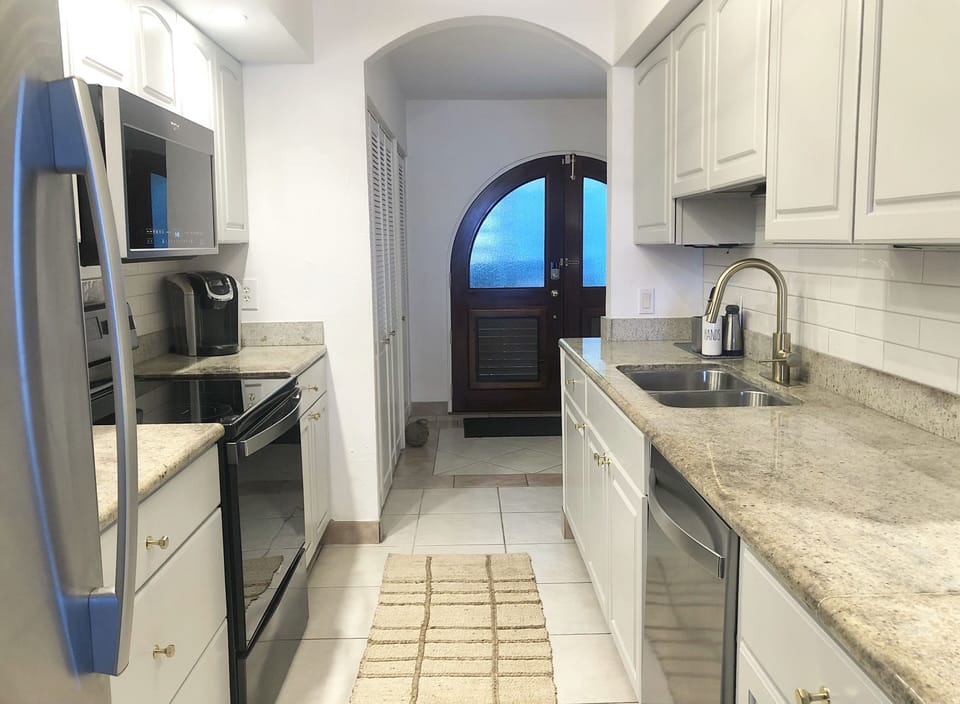 Kitchen with new stainless steel appliances, including dishwasher
