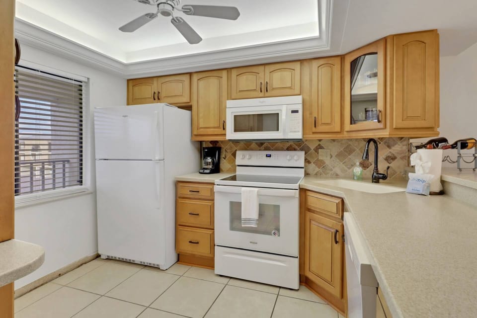 The open kitchen has abundant cabinets, full-size appliances and is well stocked with cookware, dinnerware and many kitchen tools and gadgets.