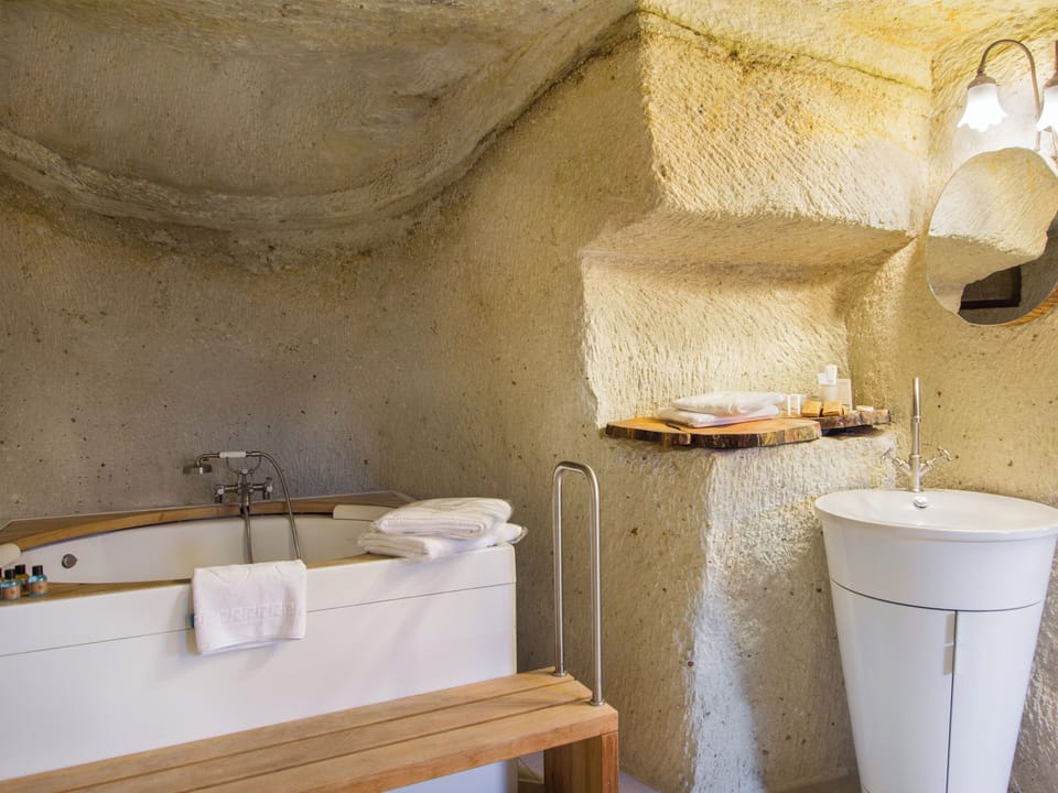 Deluxe Cave Suite | Bathroom | Designer toiletries, hair dryer, slippers, towels