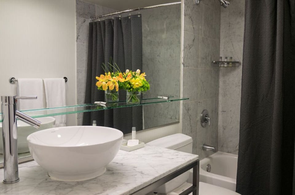 Contemporary Gallery Suite bathroom with a stylish vessel sink and fresh floral accents, offering a spa-like atmosphere.