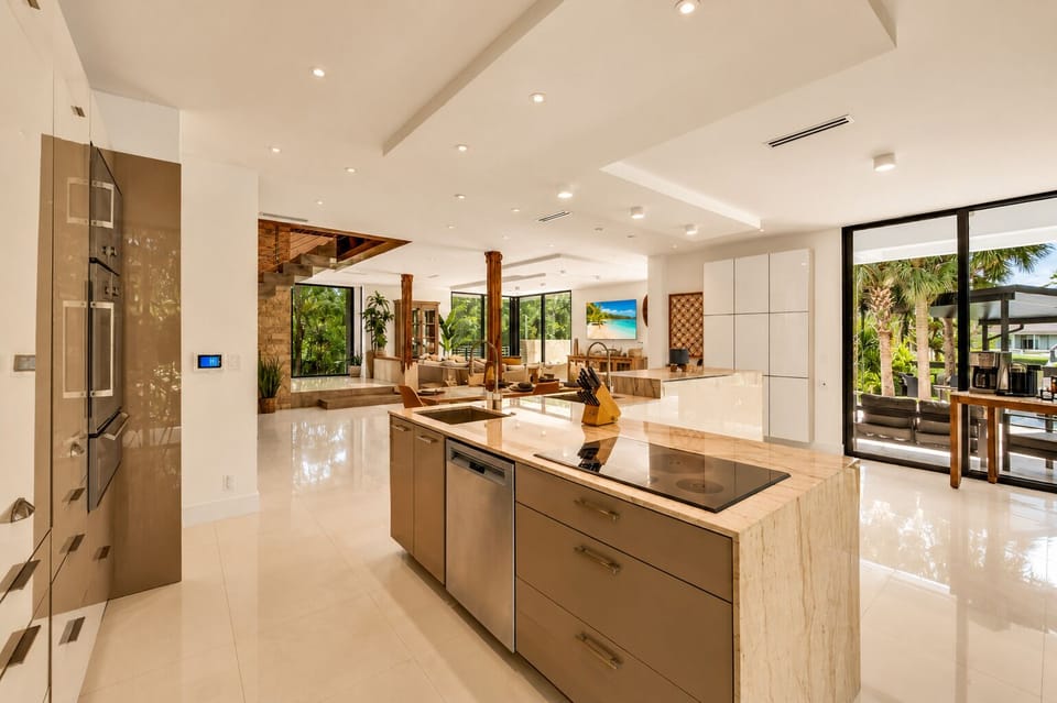 Bright luxury kitchen with waterfall island and seamless indoor-outdoor flow
