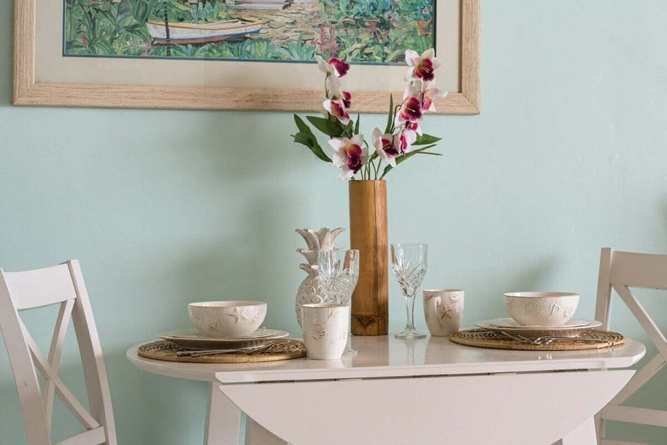 An intimate dining setup for two with elegant place settings and a simple floral centerpiece.
