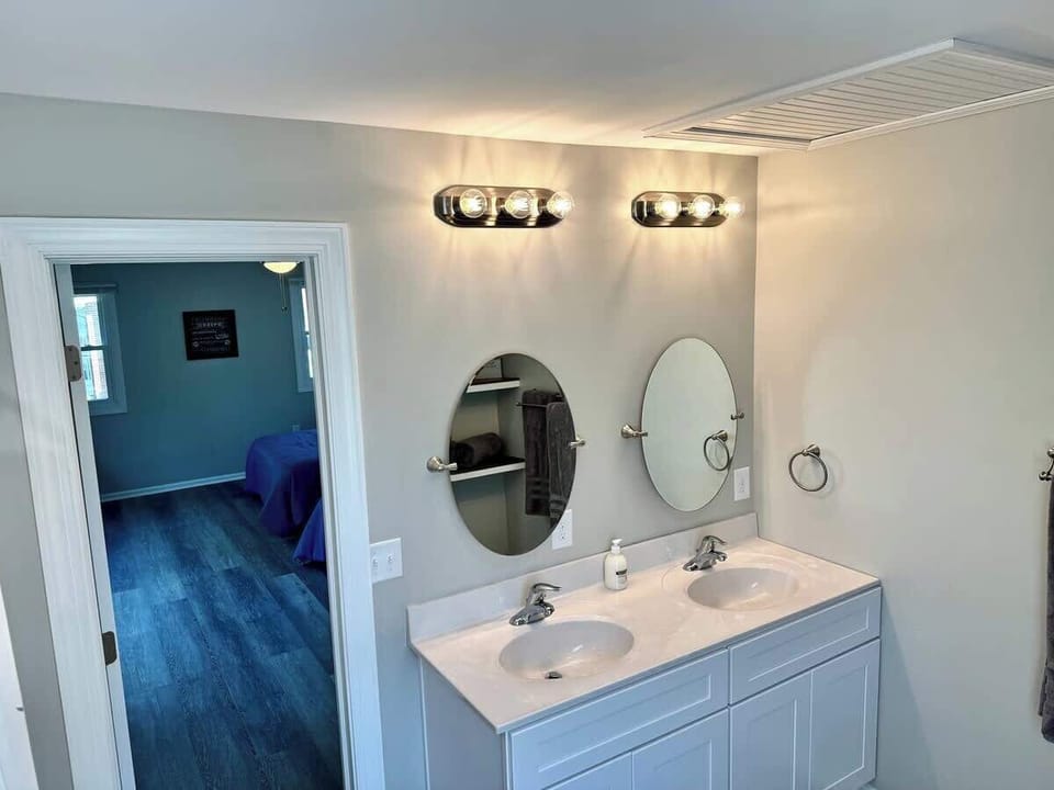 Fresh and modern bathroom with double vanity sinks. The home offers 1 bathtub and 1 walk-in shower.
