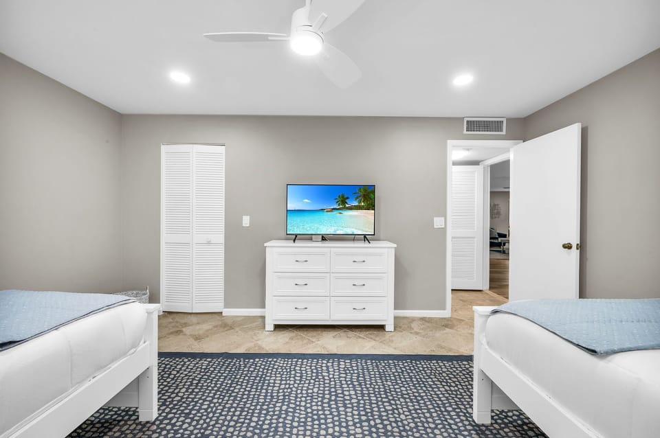 Guest bedroom with 2 full-size beds, smart streaming TV with cable, and walk in closet. Bathroom conveniently just outside this bedroom.