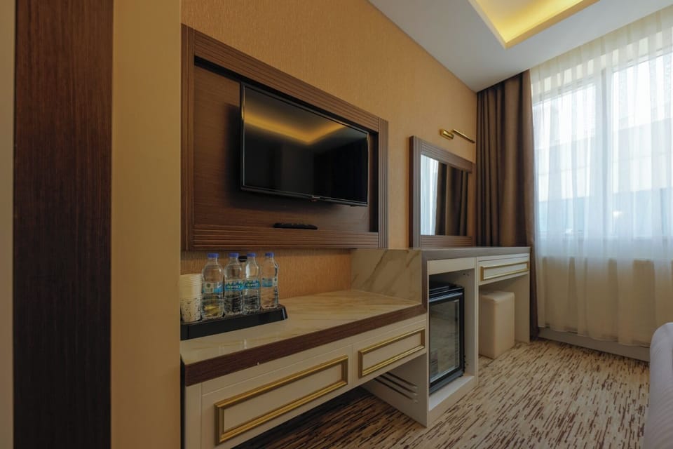 Family Triple Room, City View | Living area | 30-inch LCD TV with satellite channels