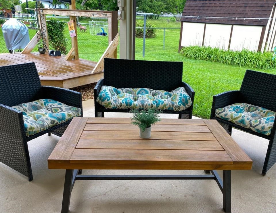 Sip coffee or wind down outdoors on the covered patio with comfortable seating and a relaxed vibe—an inviting space to enjoy your Rogers vacation rental experience.