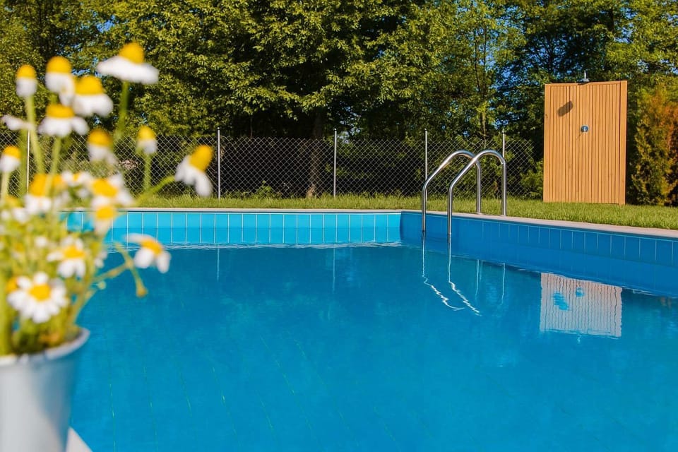Clear pool detail view – Crisp turquoise water with deck area and trees.

