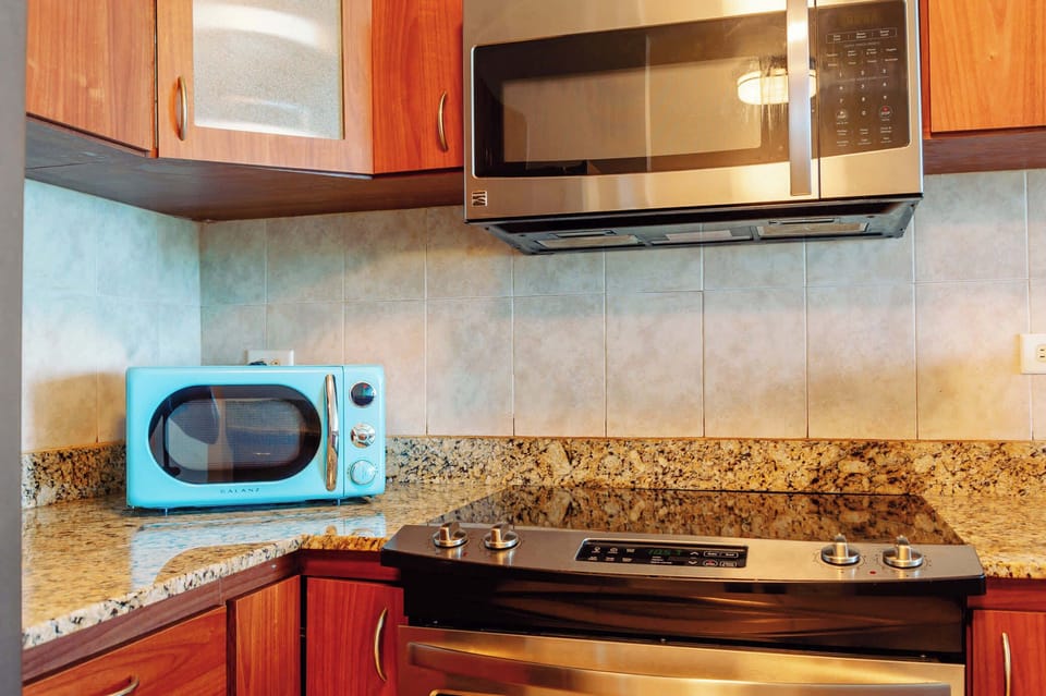 The kitchen boasts a vintage-style microwave and a modern stovetop