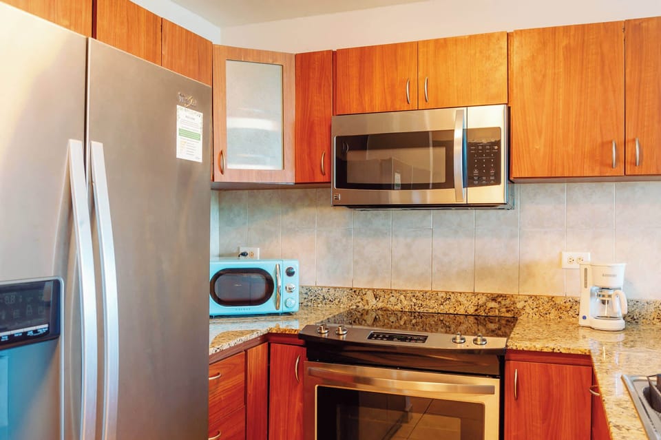 A modern kitchen appliances, including a stainless steel refrigerator, microwave, and stove