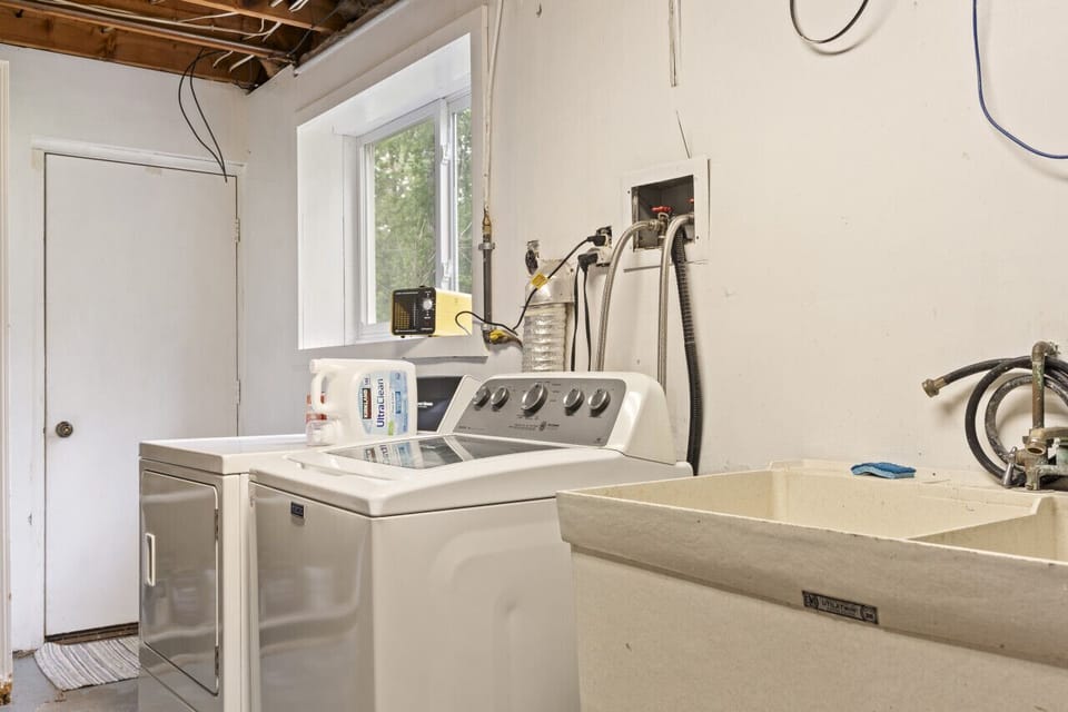 Utility room featuring a washing machine and a large sink.