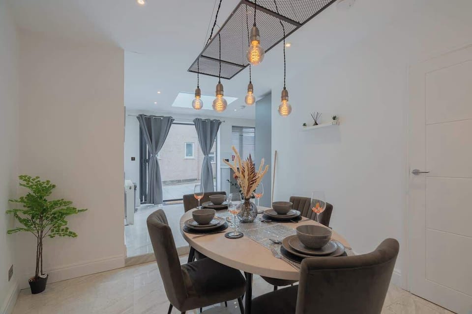 Stylish dining area with chic table for six, elegant lighting, and bright garden views — perfect for meals or meetings.
D3 Short Stays