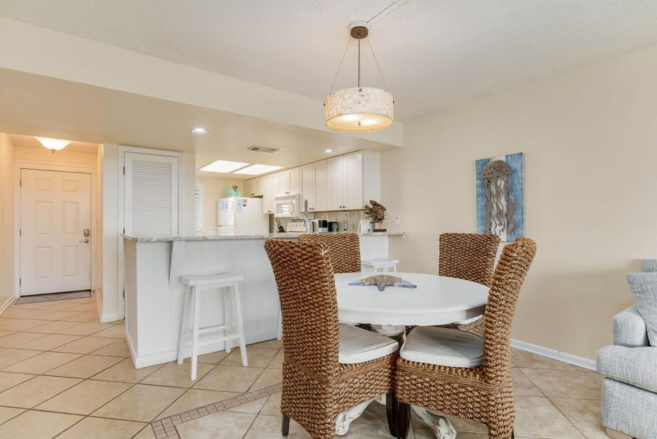 Dining table with seating for 4 and crystal chandelier at Wind Drift Orange Beach waterfront