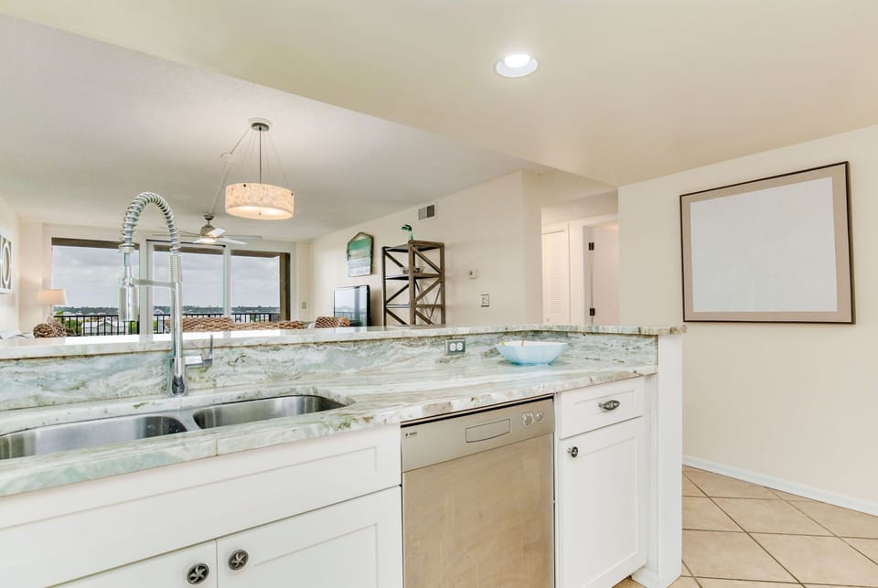 Modern kitchen with breakfast bar and stainless appliances at Wind Drift Orange Beach vacation condo