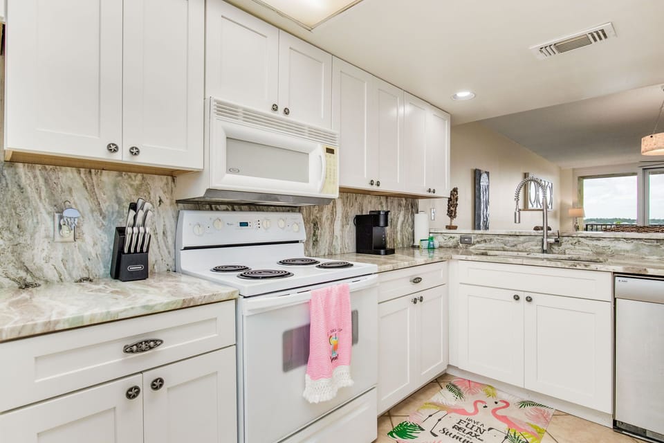 Fully equipped kitchen with white cabinets and granite counters at Wind Drift Orange Beach waterfront rental