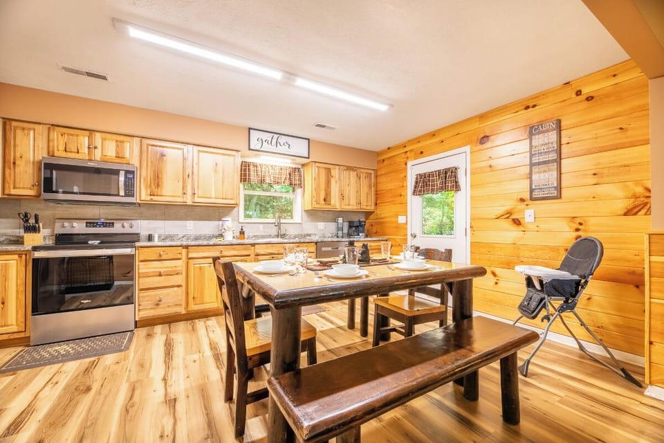 Your cabin's fully-equipped kitchen and rustic dining space invite you to gather around the handcrafted table, enjoying home-cooked meals together in warm, welcoming wood surroundings.
