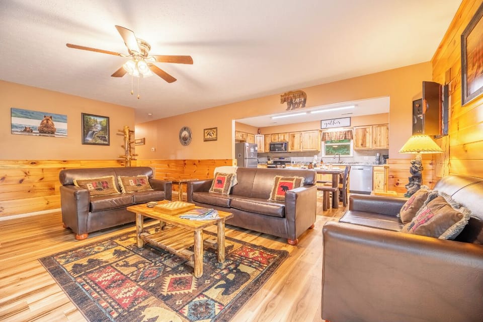 Settle into this warm, open-concept living space with plush leather sofas and rustic pine accents—your perfect mountain retreat awaits.