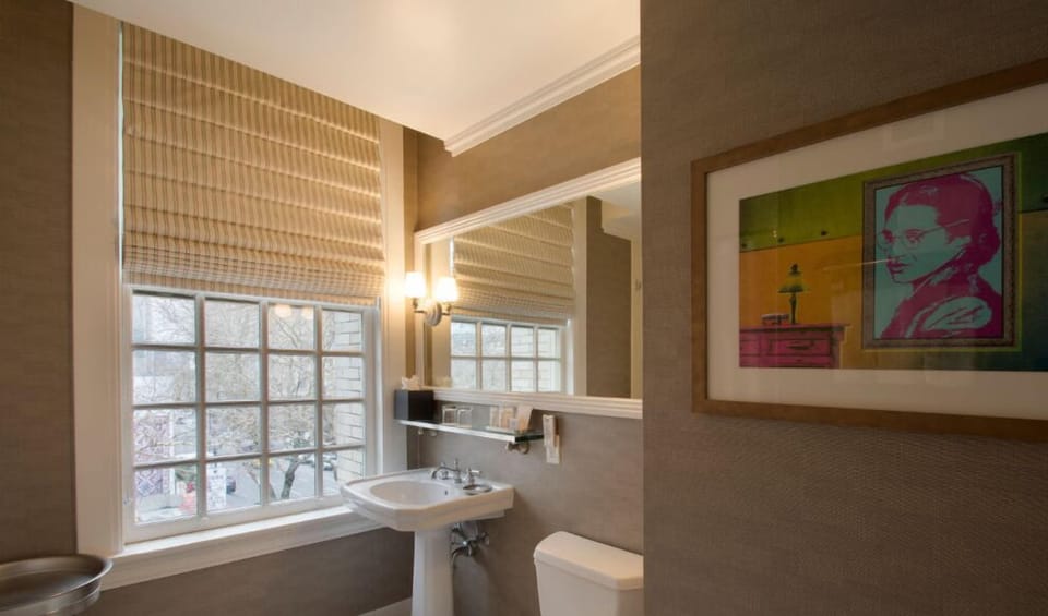 Refresh in the chic bathroom, adorned with contemporary fixtures, plenty of natural light, and stylish artwork.