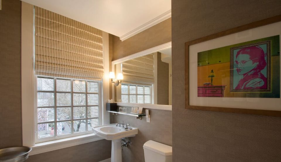 Revitalize in the stylish bathroom, showcasing sleek fixtures, plenty of natural light, and tasteful artwork.