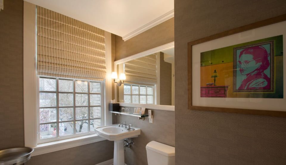 Refresh in the stylish bathroom, highlighted by contemporary fixtures, abundant natural light, and chic artwork.