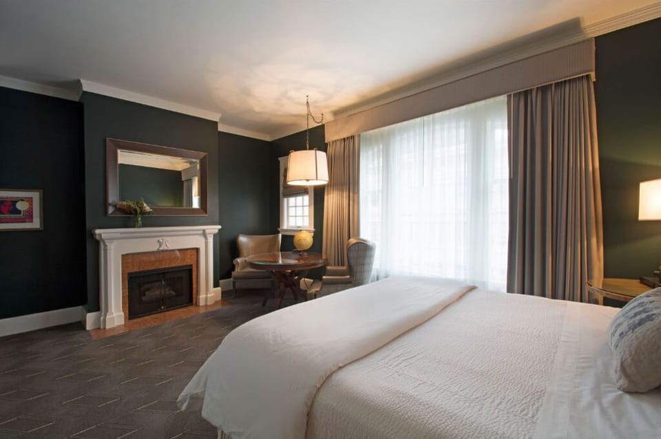 Rest peacefully in this elegant bedroom featuring a comfortable bed, cozy fireplace, and plenty of natural light.