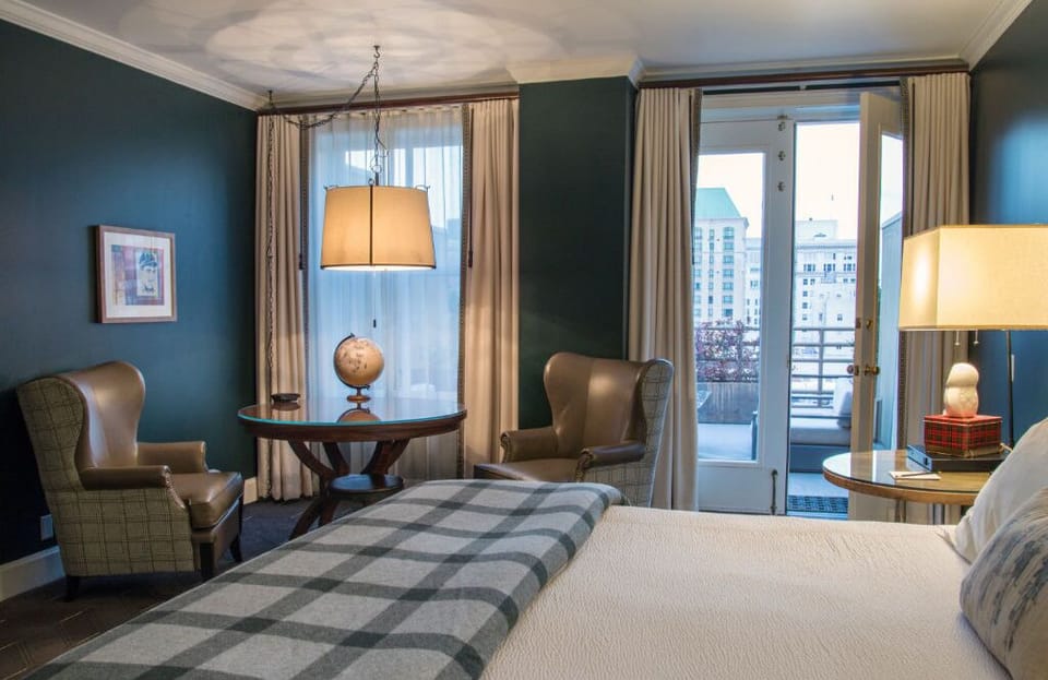 Unwind in this luxurious bedroom featuring a comfortable king bed, elegant decor, and ample natural light.