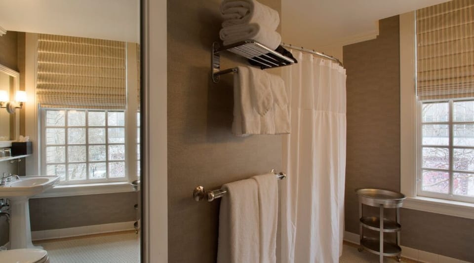 Experience a spacious shower in the well-appointed bathroom, designed with modern amenities and ample lighting.