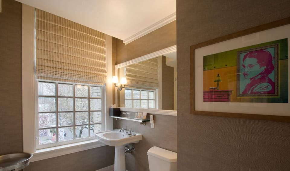 Refresh in the stylish bathroom, featuring modern fixtures, natural light, and contemporary artwork.