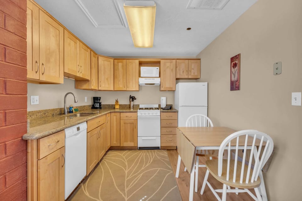 The kitchen features a kitchen table with two chairs for a comfortable eating area.