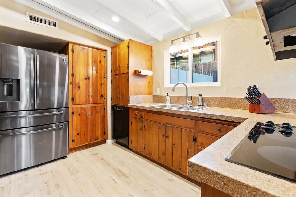 Stainless steel refrigerator and ample cabinet storage keep the kitchen well-equipped for any size group.