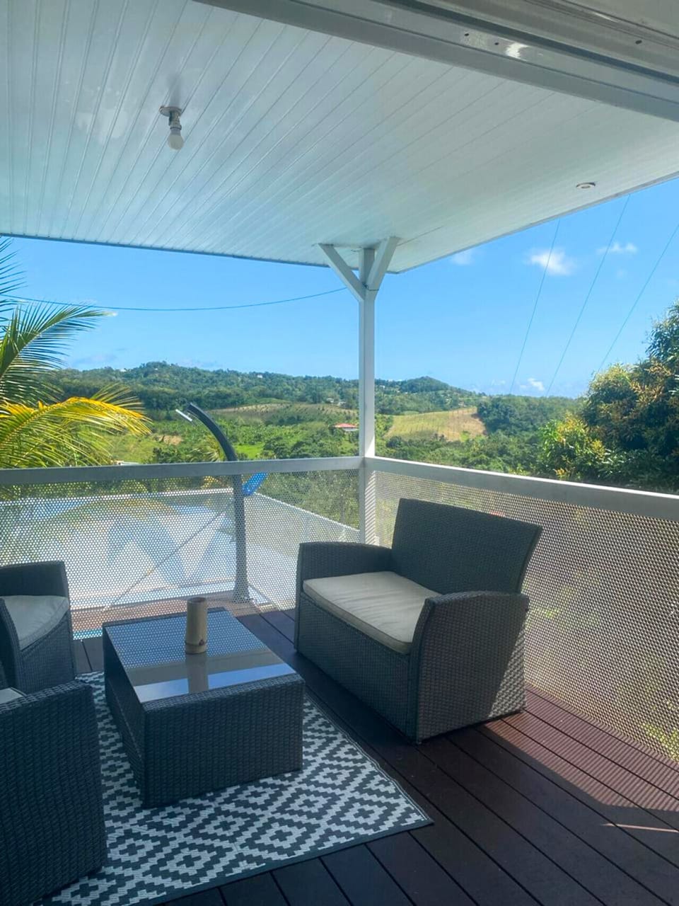 Terrasse ensoleillée avec piscine privée et vue imprenable sur la nature luxuriante de la Martinique.