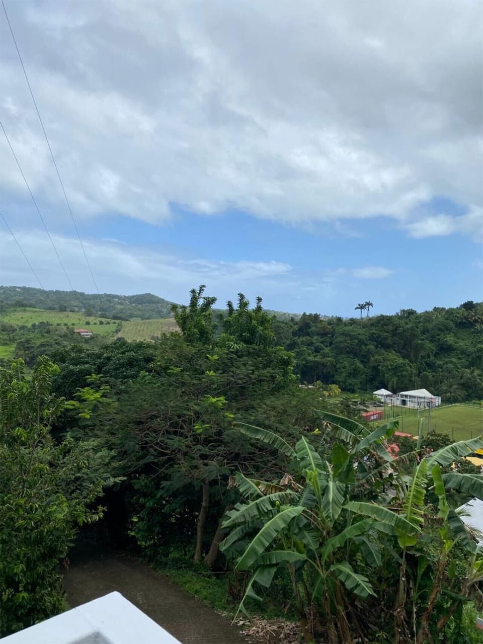 Vue panoramique sur la nature luxuriante et la vallée. Un paysage à couper le souffle, entre verdure et horizon tropical.