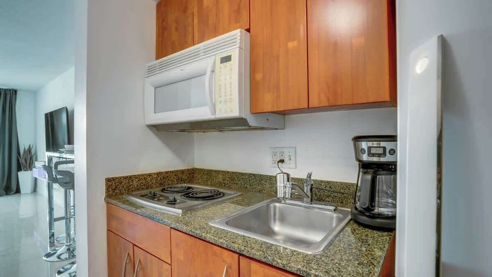 Efficiency meets elegance: A compact kitchenette, equipped with modern appliances and stylish finishes, offering convenience without compromising on sophistication in your cozy retreat.