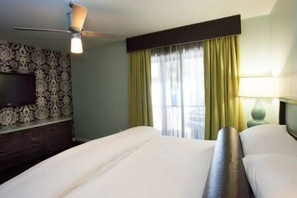 Bedroom includes flat screen TV, dresser, night stand, and access to patio