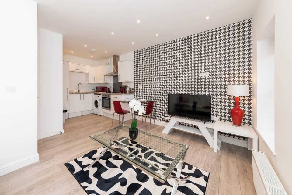 Stylish open-plan living area with bold feature wall, modern furnishings, and seamless flow into the fully equipped kitchen.