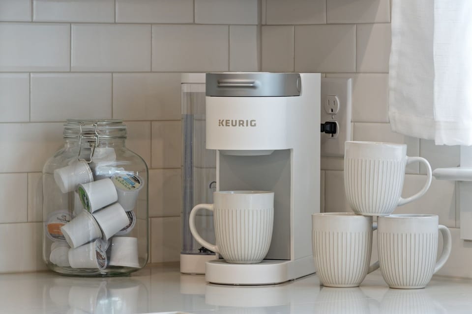 Keurig coffee maker with mugs and coffee capsules