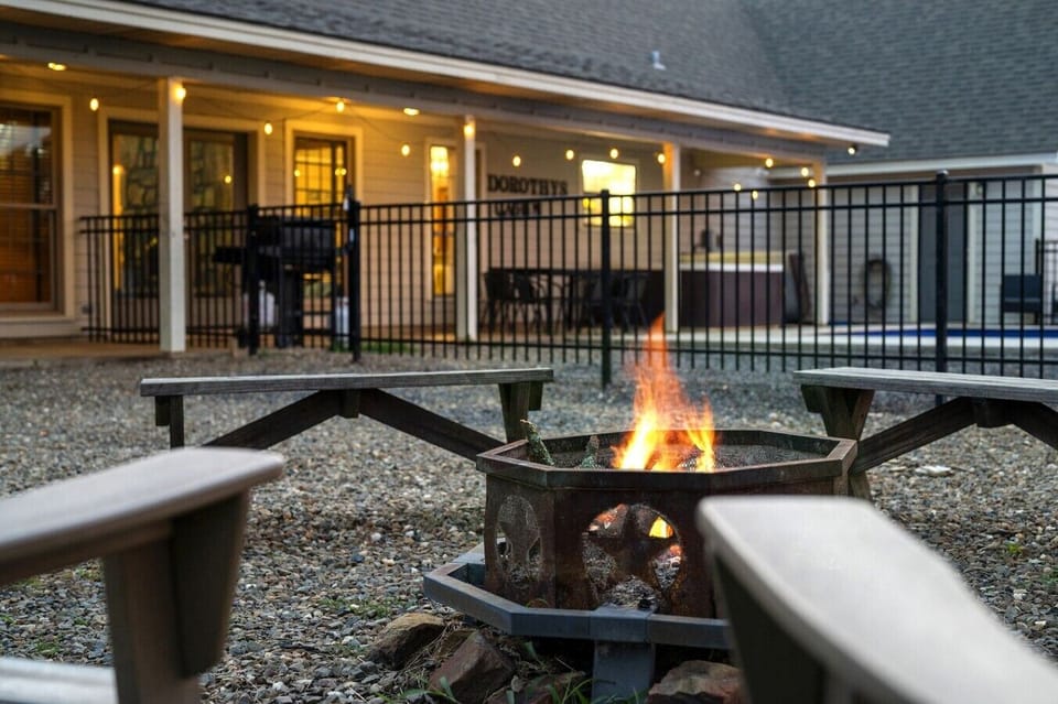 Fire pit lounge beside the pool and covered patio.