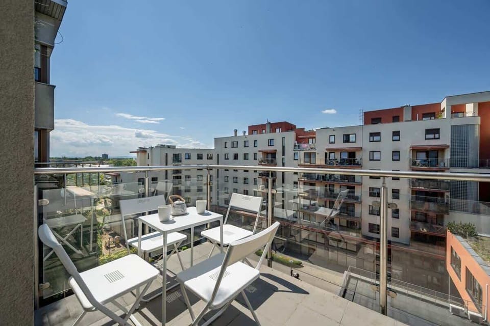 The balcony with a coffee set invites you to enjoy fresh air and quiet moments surrounded by modern architecture.