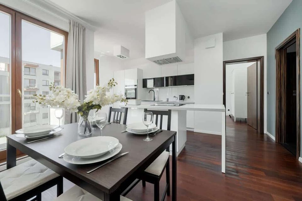 The open dining area with white flowers and natural light creates an elegant space for shared meals and conversations.